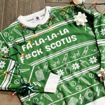 Load image into Gallery viewer, Flat lay of the Fa-La-La-La F*ck SCOTUS Holiday Sweater. There are colorful holiday lights on it and bows and ornaments around it.
