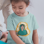 Load image into Gallery viewer, Toddler wearing Malala t-shirt from The Outrage sitting next to an adult while they read a picture book.