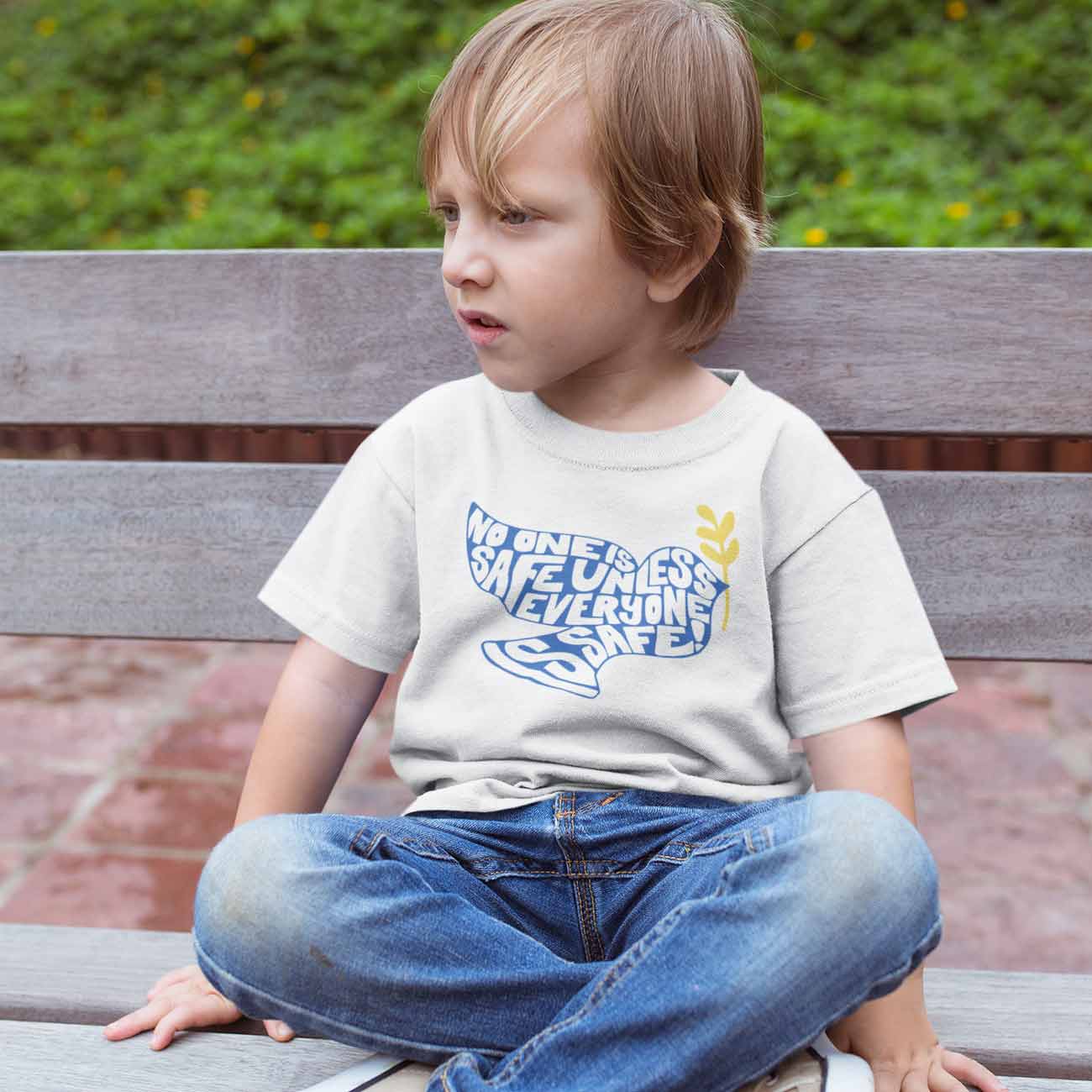 Image of child wearing the No One Is Safe Unless Everyone Is Safe tee.
