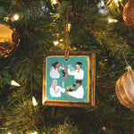 Load image into Gallery viewer, Square wooden ornament with four diverse women in lab coats with scientific equipment on a teal background
