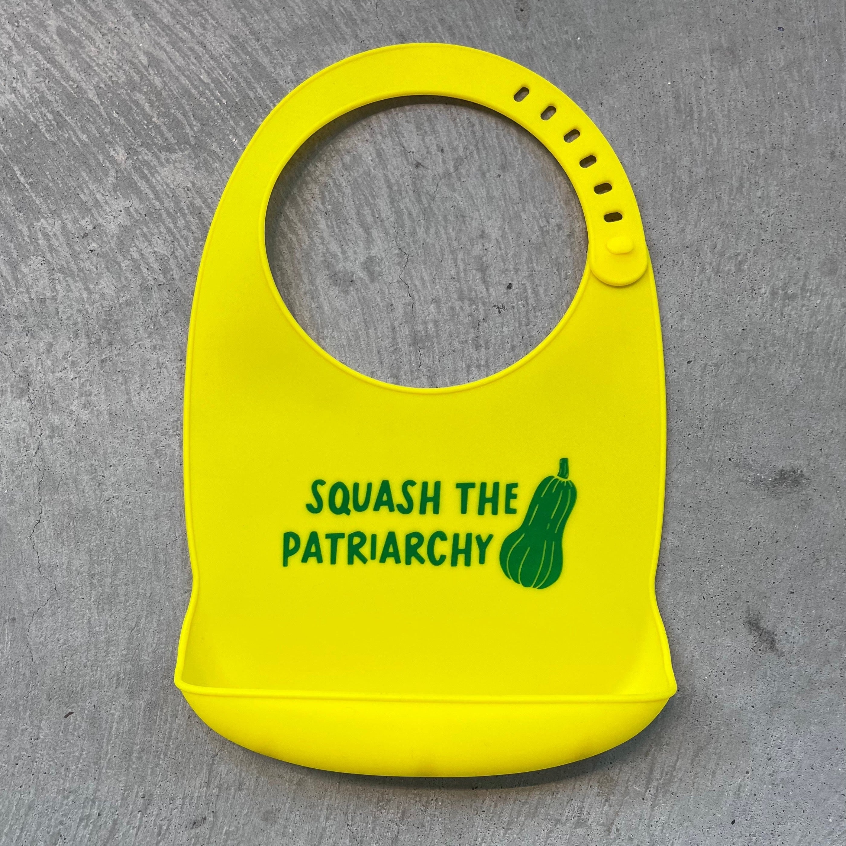  Yellow silicon bib with pocket and green design "Squash The Patriarchy"