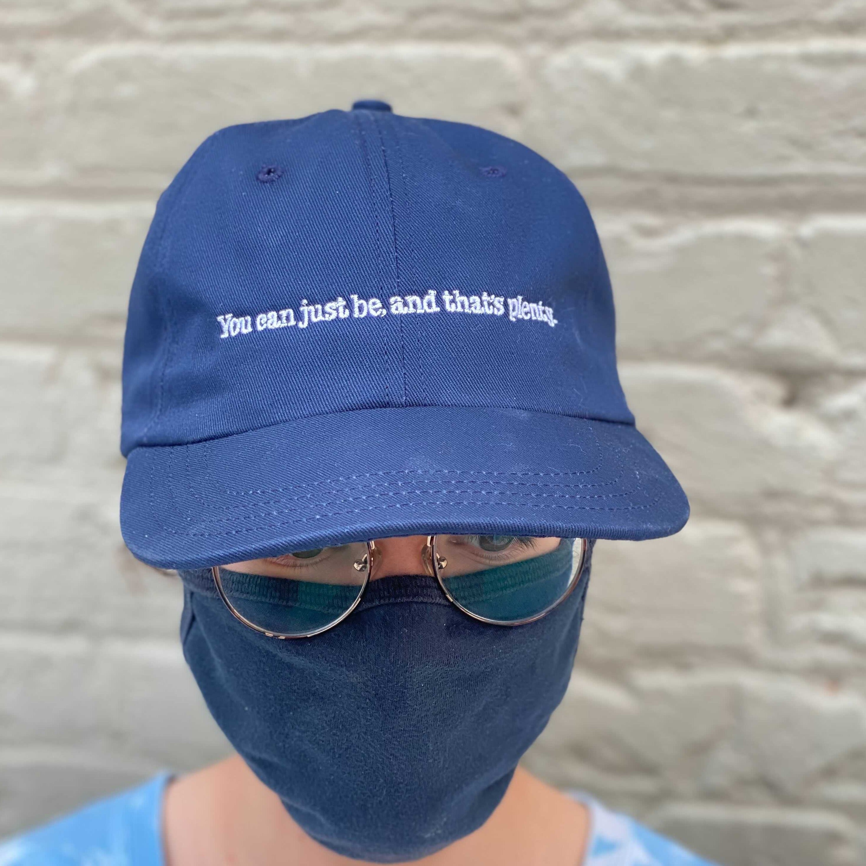 Person wearing Alice Walker "You can just be, and that's plenty" cap