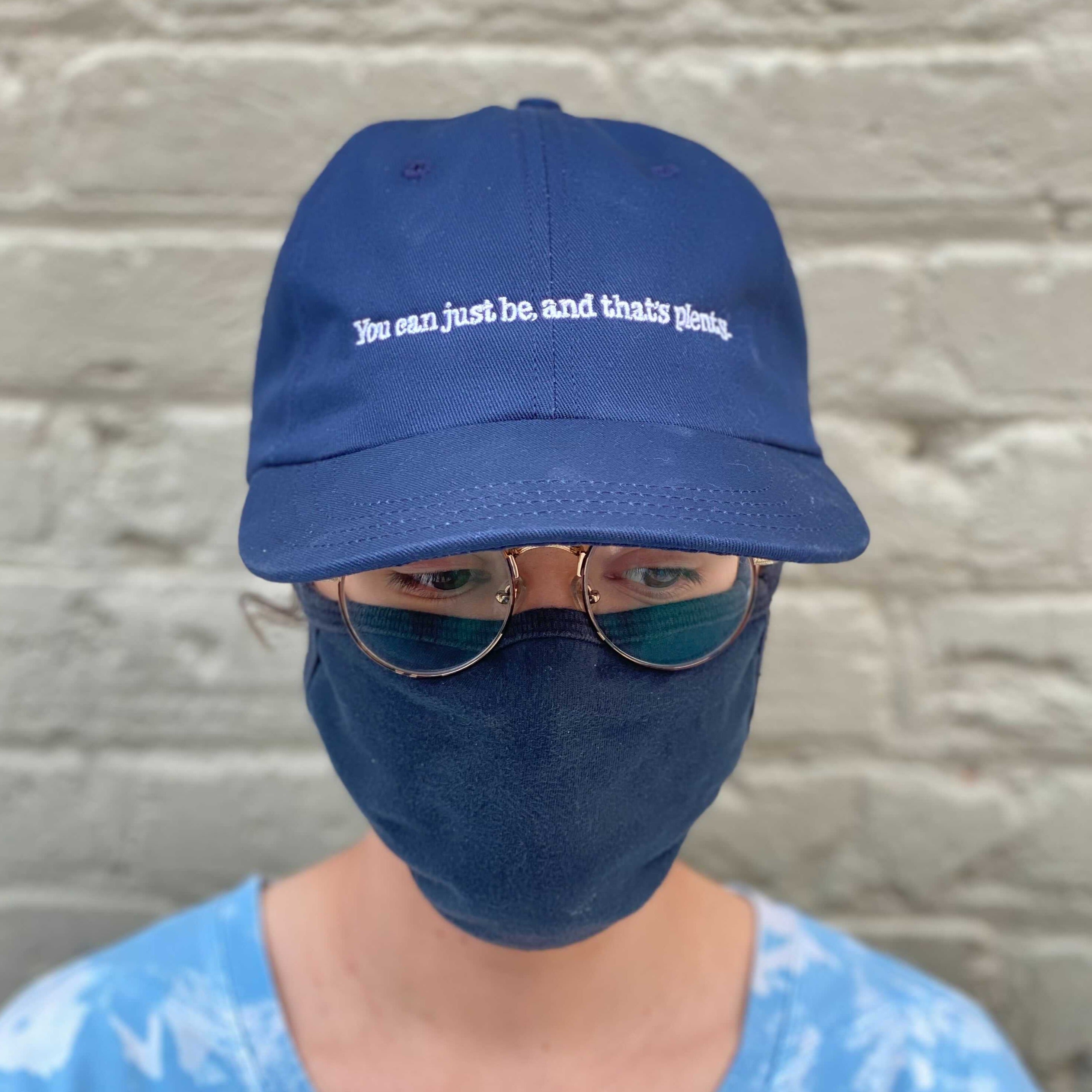 Person wearing Alice Walker "You can just be, and that's plenty" cap