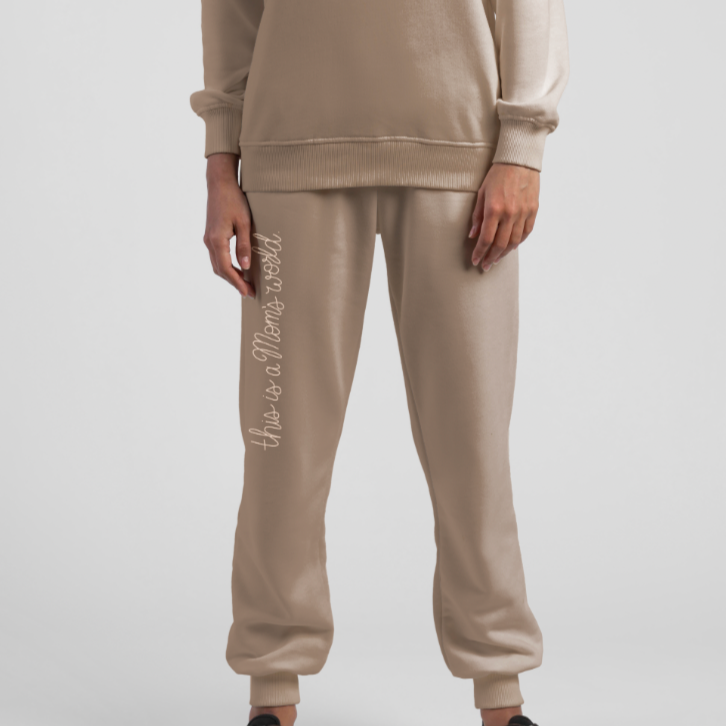 Person standing wearing Ma'am Shoes "This Is A Mom's World" sweatpants and sweatshirt.