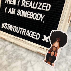 Photo of the sisterhood sticker next to a sign.
