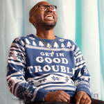 Load image into Gallery viewer, A person wearing the Get In Good Trouble Holiday Sweater. There is an ice blue background.
