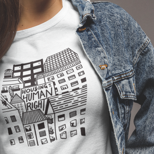 Person wearing Housing Is A Human Right Tee