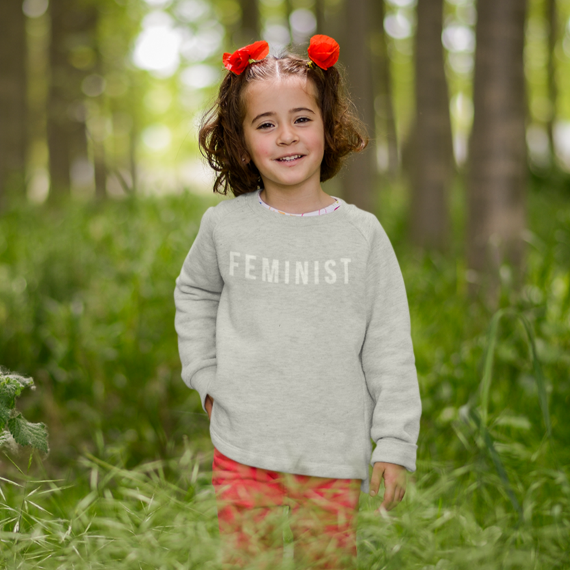 Image of little girl wearing the Feminist Toddler Crewneck Sweatshirt.