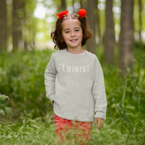 Image of little girl wearing the Feminist Toddler Crewneck Sweatshirt.