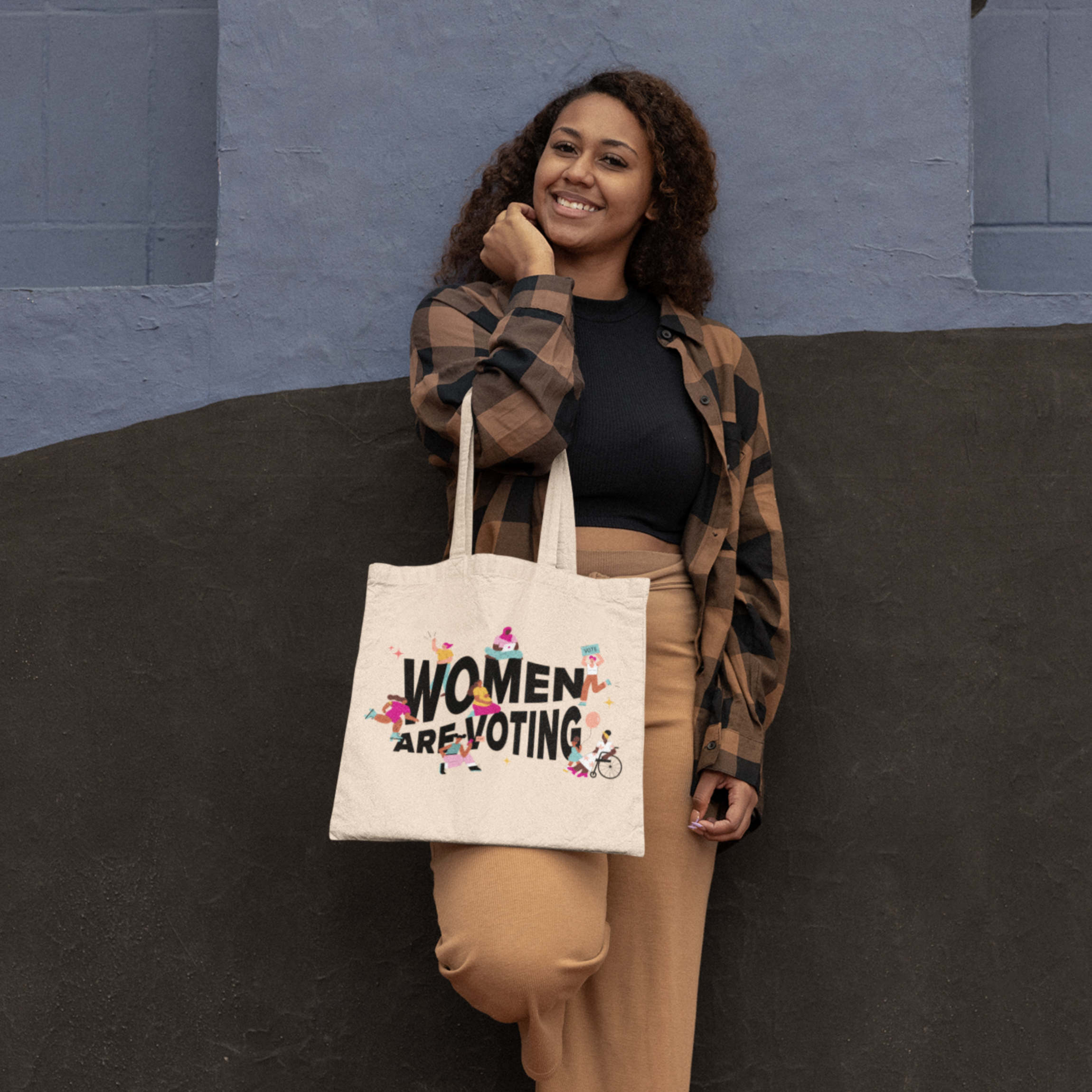 Photo of a person holding the Women Are Voting tote bag.